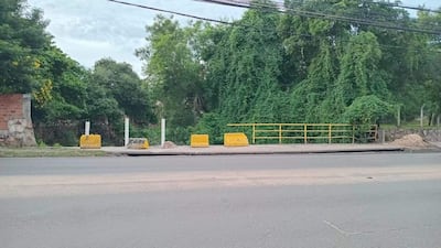 Escena de la avenida Artigas con infraestructura en amarillo y bloques de concreto, rodeada de vegetación densa.