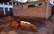 Ambiente de construcción con muro de ladrillos y montones de tierra, sin personas presentes en la escena.