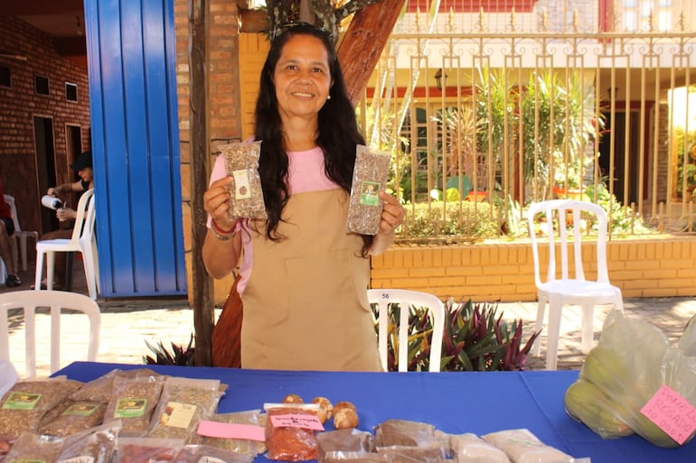Doña Nimia Ruiz atiende con entusiasmo a los visitantes de su puesto, ofreciendo productos frescos y accesibles.