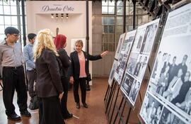 Esperanza Ortiz (derecha) hija de Demetrio, mostrando a los visitantes algunas de las fotografías que forman parte de la muestra.