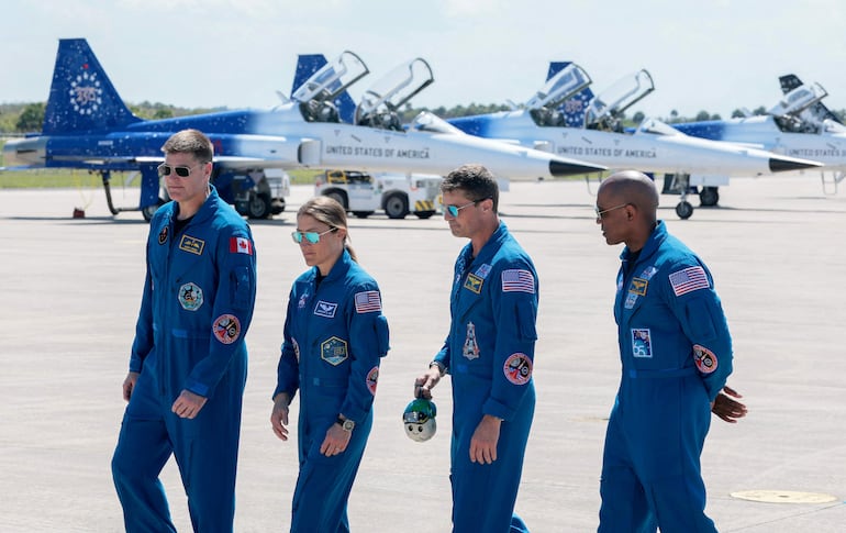 La tripulación de Artemis II —de izquierda a derecha, el especialista de misión Jeremy Hansen de la Agencia Espacial Canadiense (CSA), la especialista de misión Christina Koch, el comandante Reid Wiseman y el piloto Victor Glover— camina junta tras llegar al Centro Espacial Kennedy el 27 de marzo de 2026 en Cabo Cañaveral, Florida.