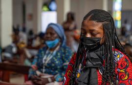 Personas con mascarillas participan de una misa en una iglesia en Bunia, República Democrática del Congo, ayer domingo.