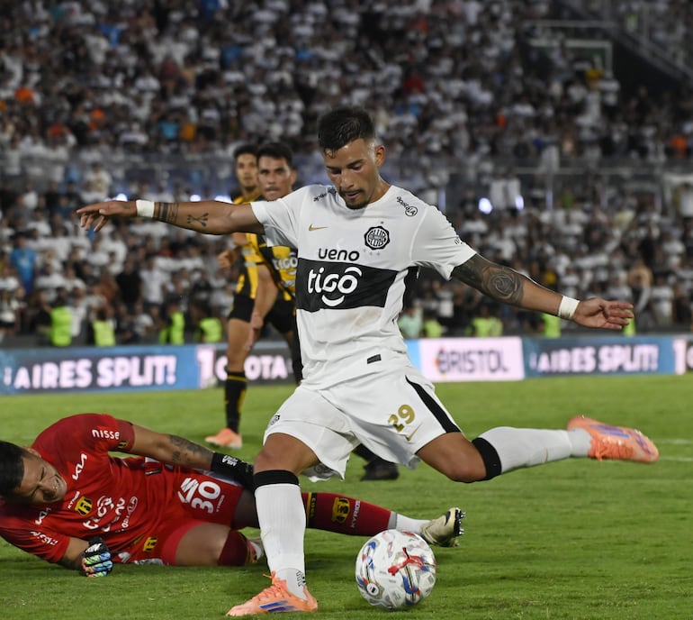 Iván Leguizamón marca el segundo tanto de Olimpia en el partido tras eludir a Aldo Pérez, quien quedó tendido en el césped y que pudo haber sufrido una lesión en la rodilla izquierda grave.