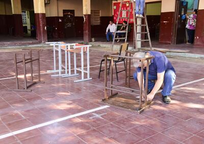 El profesor de Historia y Ética, Gerardo Aquino, atornillando una mesa pedagógica para el primer día de clases.