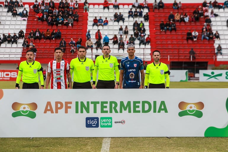Los capitanes posan junto a la terna arbitral.