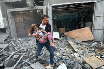 Un hombre lleva en brazos a una niña herida que fue rescatada de un edificio dañado por un bombardeo israelí el pasado jueves en Yabalia, en el norte de la Franja de Gaza.