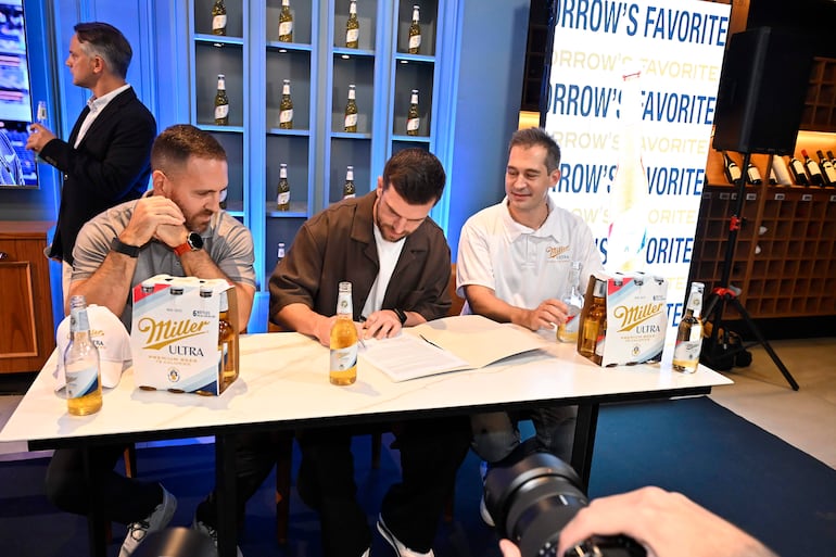 Momento en el que Tim Payne firma el contrato como embajador de Miller Ultra Premium Beer, en Distribuidora Gloria.