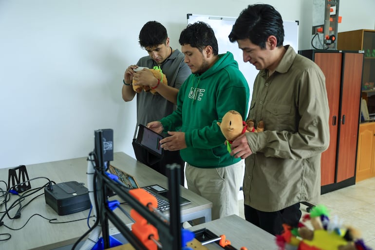 Fotografía del 13 de octubre de 2026 del estudiante de mecatrónica de la Universidad UTE Josué Espín (c) junto a sus compañeros Mateo Fabara (i) e Israel Robayo, trabajando en un laboratorio durante una entrevista con EFE en Quito (Ecuador).