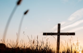 Una cruz de madera se recorta contra el cielo al atardecer, símbolo central de la Semana Santa y de los días de reflexión, silencio y fe que marcan esta celebración.