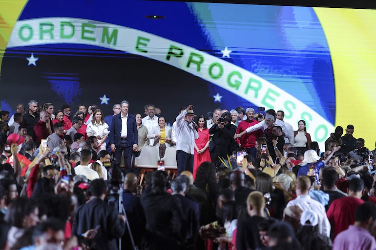 El presidente de Brasil, Luiz Inácio Lula da Silva (c), reacciona en la convención nacional del Partido de los Trabajadores de Brasil (PT) este domingo, en Sao Paulo (Brasil). A sus 80 años y con las encuestas de intención de voto a su favor, Lula vuelve a vestir el traje de candidato para conseguir un histórico cuarto mandato no consecutivo y consolidar a Brasil como el principal bastión del progresismo en la región. 