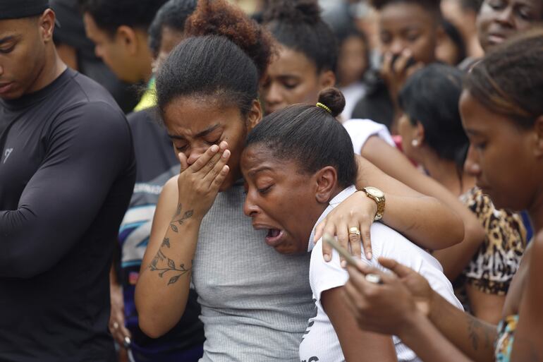 Personas lloran en una calle donde se encuentran cuerpos sin vida este miércoles, en Río de Janeiro (Brasil). 