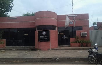 Fachada del Ministerio Público en un entorno urbano, con paredes de ladrillo rojo y una motocicleta estacionada a la derecha.