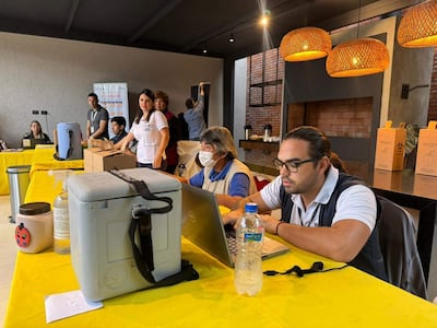 Grupo de seis personas trabajan en laptops esperando que lleguen las primeras personas para vacunarse contra la Influenza y el Neumococo.