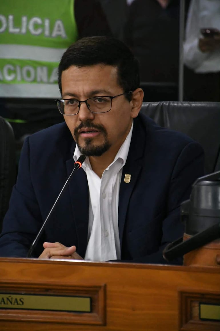 Miguel Sosa habla ante un micrófono, vestido con blazer oscuro y camisa blanca, en un ambiente institucional.