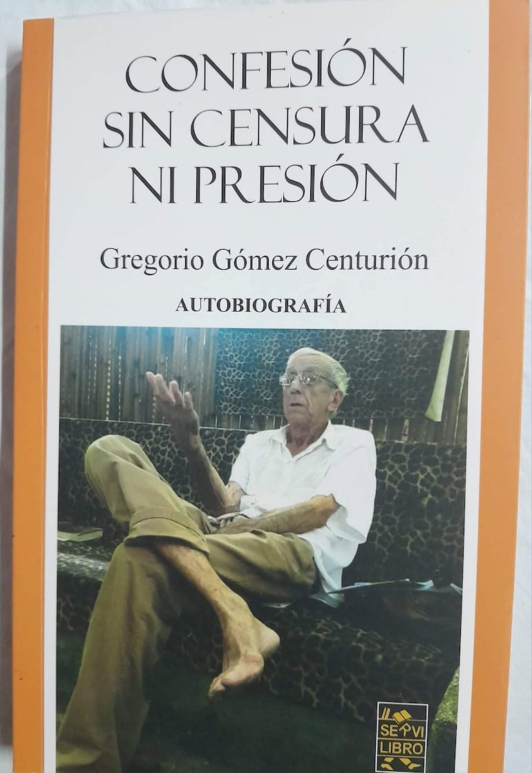 Gregorio Gómez Centurión, con cabello canoso y gafas, gesticula sentado en un sofá mientras presenta su libro en un entorno sencillo.