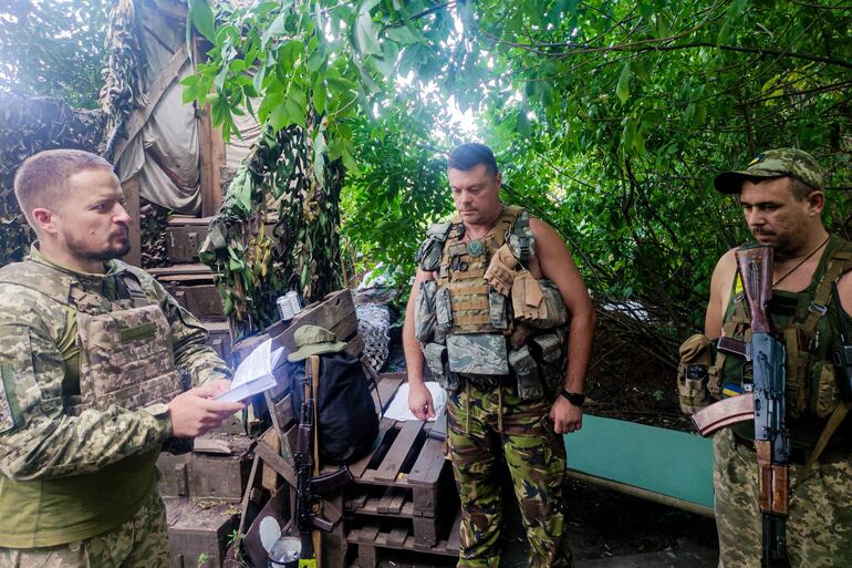 Un capellán militar ortodoxo dirige una oración en una de las posiciones ucranianas junto a la frontera con Rusia.