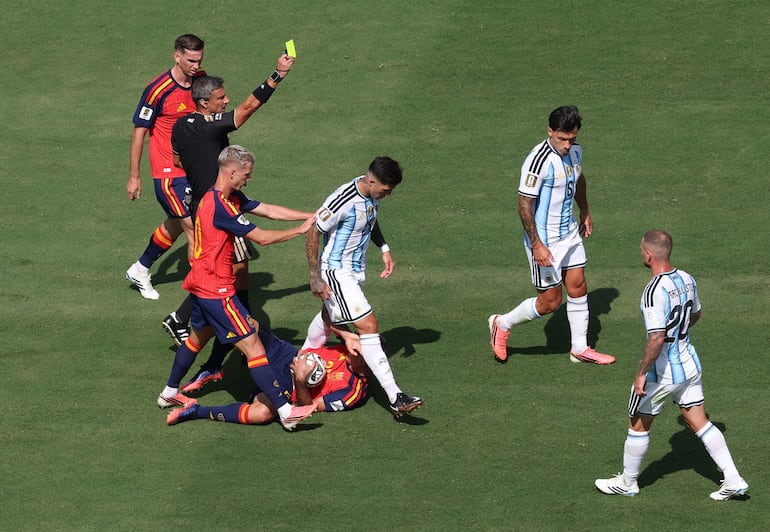 El árbitro Slavko Vincic (2do izq.) muestra una tarjeta amarilla al argentino Lisandro Martínez (2do der.) durante el partido de la final de la Copa Mundial de la FIFA 2026 entre España y Argentina, en Nueva Jersey, EE. UU..