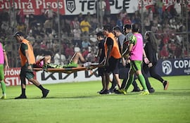 El defensor, Alexis "Pulpito" Duarte, retirado en camilla del terreno de juego del Gunther Vogel, tras sufrir la lesión ligamentaria en su estreno con la camiseta de Libertad