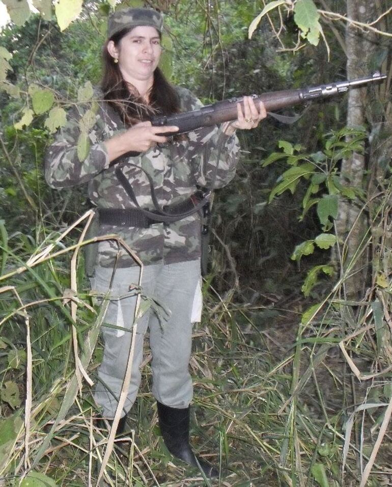 Lourdes Bernarda Ramírez de Ramos, vestida con un uniforme camuflado y portando un fusil.