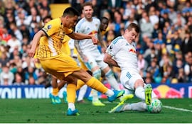 Jugadores en acción, uno con camiseta amarilla y otro con camiseta blanca de Red Bull, mientras el público aplaude emocionado.