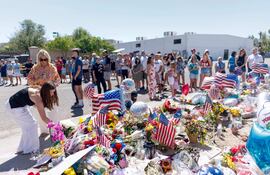Personas visitan un memorial por Charlie Kirk en la sede de Turning Point USA el 13 de septiembre de 2025 en Phoenix, Arizona.