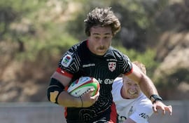 El jugador del Selknam se escapa del capitán Ramiro Amarilla.