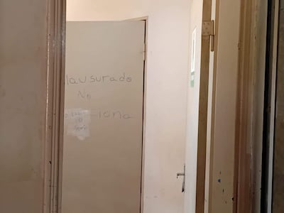 Pasillo vacío en el Hospital Nacional de Itauguá con puertas cerradas y carteles manuscritos de 'No Abrir'.