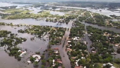 Vista aérea de Cerrito inundado, con casas inundadas y árboles emergiendo en un paisaje acuático bajo un cielo despejado.