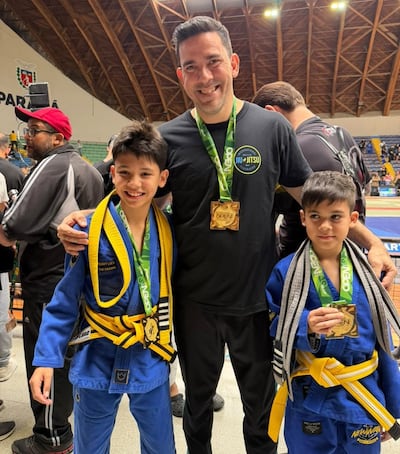 Diego Fernando León Narvaja y sus hijos, Juan Pablo y Alejandro León Enciso, con sus respectivas medallas doradas alcanzadas en la competencia de jiu-jitsu en Curitiba, Brasil.
