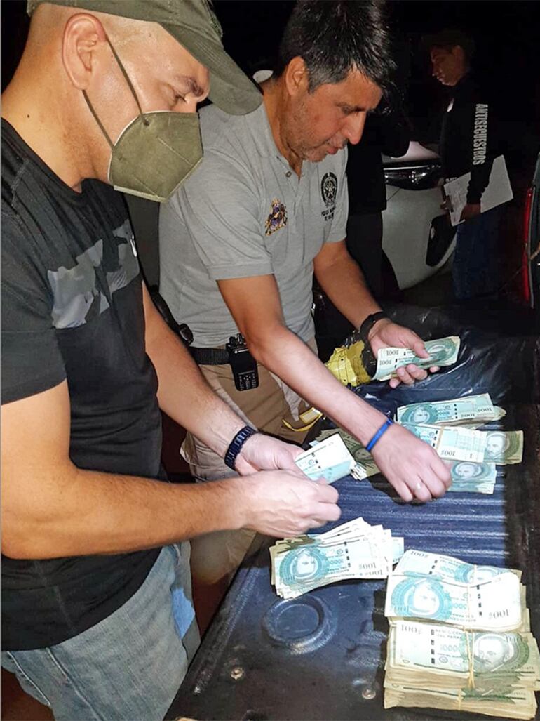 Investigadores de la Policía Nacional y el Ministerio Público verifican los billetes encontrados en poder del Alfredo Benítez, capturado cuatro días después del crimen.