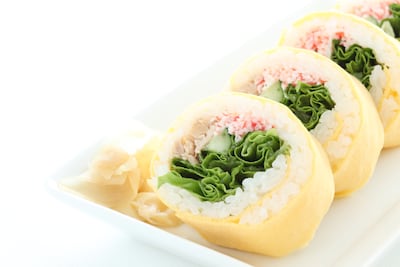 Roll fusión envuelto en huevo estilo tamagoyaki.