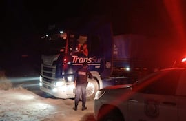 Un policía uniformado realiza control a conductor de un camiòn