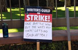 Un cartel que reza "Una batalla ganada, pero la guerra aún no finalizó. Vamos SAG-AFTRA", en referencia a la finalización de la huelga de guionistas y la continuidad del paro de actores.