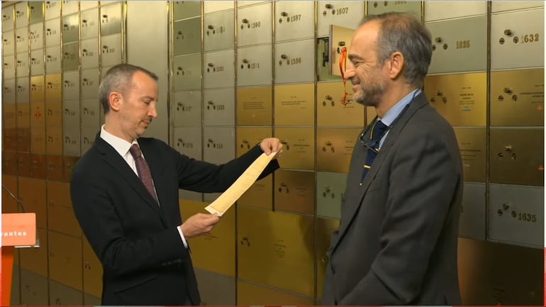 El embajador Javier Parrondo, acompañado por Miguel Albero del Instituto Cervantes, observa el poema inédito que se introdujo a la Caja de las Letras.