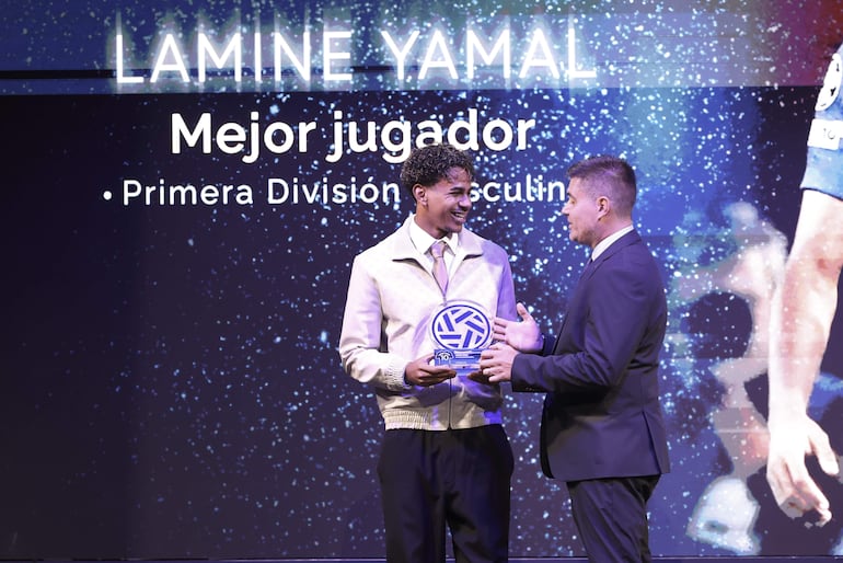 El presidente de la Asociación de Futbolistas Españoles (AFE), David Aganzo, entrega un premio al delantero del FC Barcelona Lamine Yamal. (EFE/Kiko Huesca)
