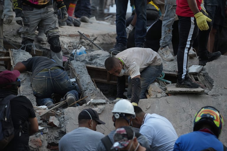 Personas trabajan en labores de rescate en una edificación colapsada por el terremoto de magnitud 7,4 que sacudió al país este lunes, en Cali (Colombia). EFE