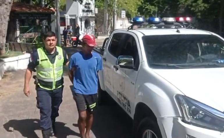 Un policía dirige al detenido Adolfo Bogado hasta el interior de la comisaría 13° Asunción.