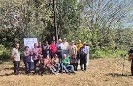 Mujeres y hombres aplauden mientras un hombre toca la guitarra, celebrando en un ambiente rural soleado.