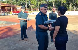 El comandante del Segundo Cuerpo de Ejército, general de división, Narciso López, entregando el uniforme a una de la nuevas cimeforistas.