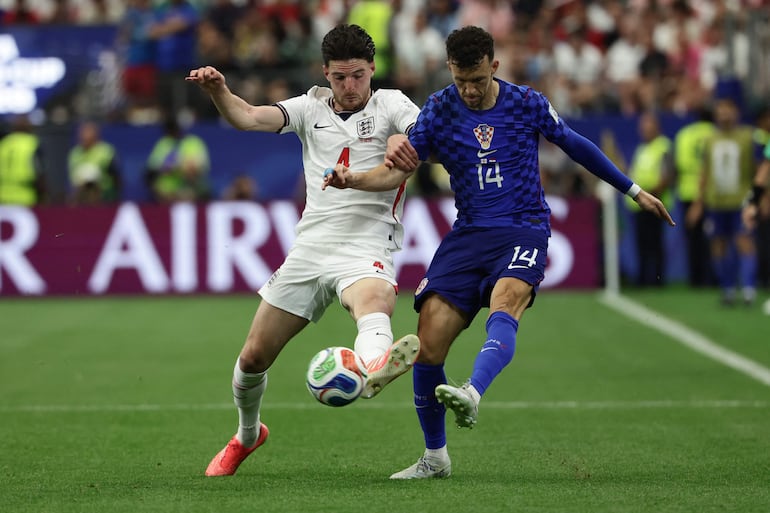 El mediocampista de Inglaterra, Declan Rice (I), y el delantero de Croacia, Ivan Perisic (D), luchan por el balón durante el partido de fútbol del Grupo L de la Copa Mundial 2026 entre Inglaterra y Croacia en el Dallas Stadium en Arlington.