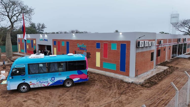 Edificio nuevo 'Semillas del Futuro' con un bus azul destacado frente a un terreno en construcción.
