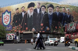 FOTODELDÍA Teherán (Irán ), 21/05/2026.- Ciudadanos iraníes caminan frente a una gran valla publicitaria con imágenes del difunto líder supremo iraní, el ayatolá Ali Jamenei, y del difunto presidente iraní, Ebrahim Raisi, en la plaza Enghelab de Teherán, Irán, este jueves. Las tensiones entre Estados Unidos e Irán continúan al no haberse alcanzado un acuerdo.EFE/ Abedin Taherkenareh
