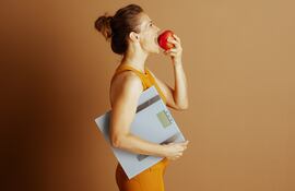 Mujer con una manzana en la boca.