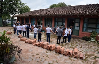 Niños en un juego de integración el primer día de clases, en medio de tejas de una obra en la escuela General Andrés Rodríguez.