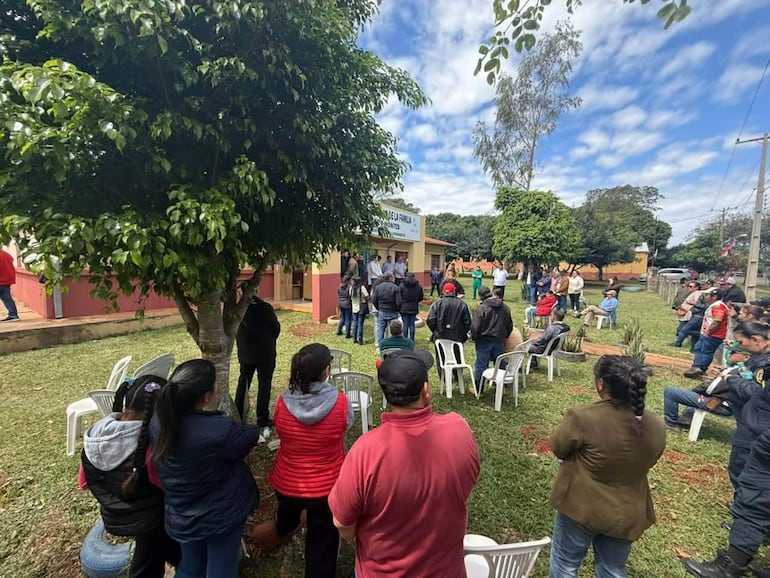 Cristina Villalba rodeada de pobladores, expresiones de descontento y un ambiente comunitario en un evento de salud.