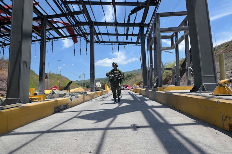 
Un soldado hace guardia después de que una plaza de peaje fuera atacada en Santander de Quilichao, departamento del Cauca, Colombia, el 8 de agosto de 2026. 