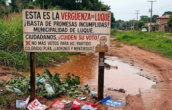 Cartel instalado en una calle que en los "papeles está asfaltada".