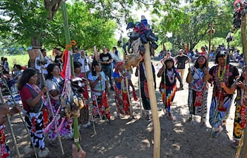 Mujeres del pueblo Maka con trajes tradicionales y varas adornadas, compartiendo alegría en un ambiente natural durante la celebración.