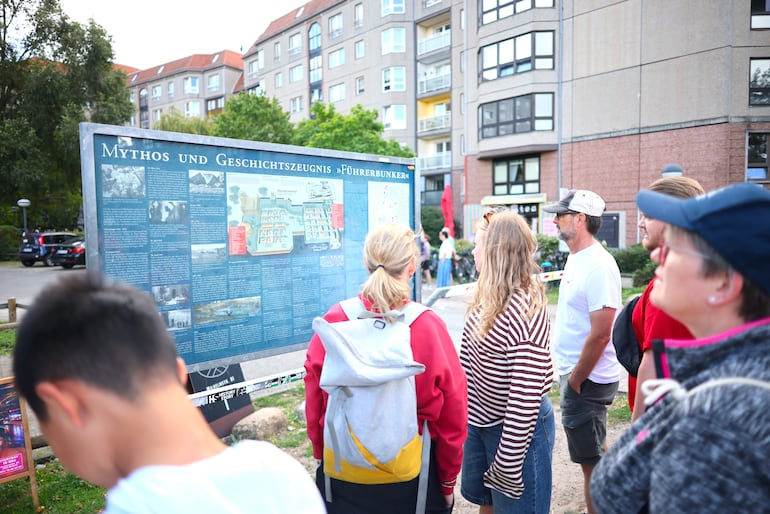 Turistas se encuentran frente al cartel informativo sobre el búnker del Führer, cerca de lo que fue la Nueva Cancillería del Reich, en Berlín, Alemania, el 11 de agosto de 2026.