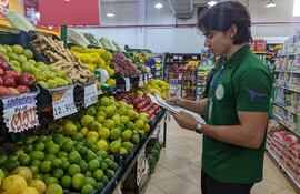 Un estudiante verifica los precios de las frutas en un supermercado de Ciudad del Este.